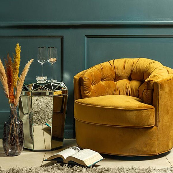 یک عدد مبل راحتی یک نفره با روکشی زرد رنگ در اتاق قرار دارد که یک کتاب نیز در مقابل آن موجود است.